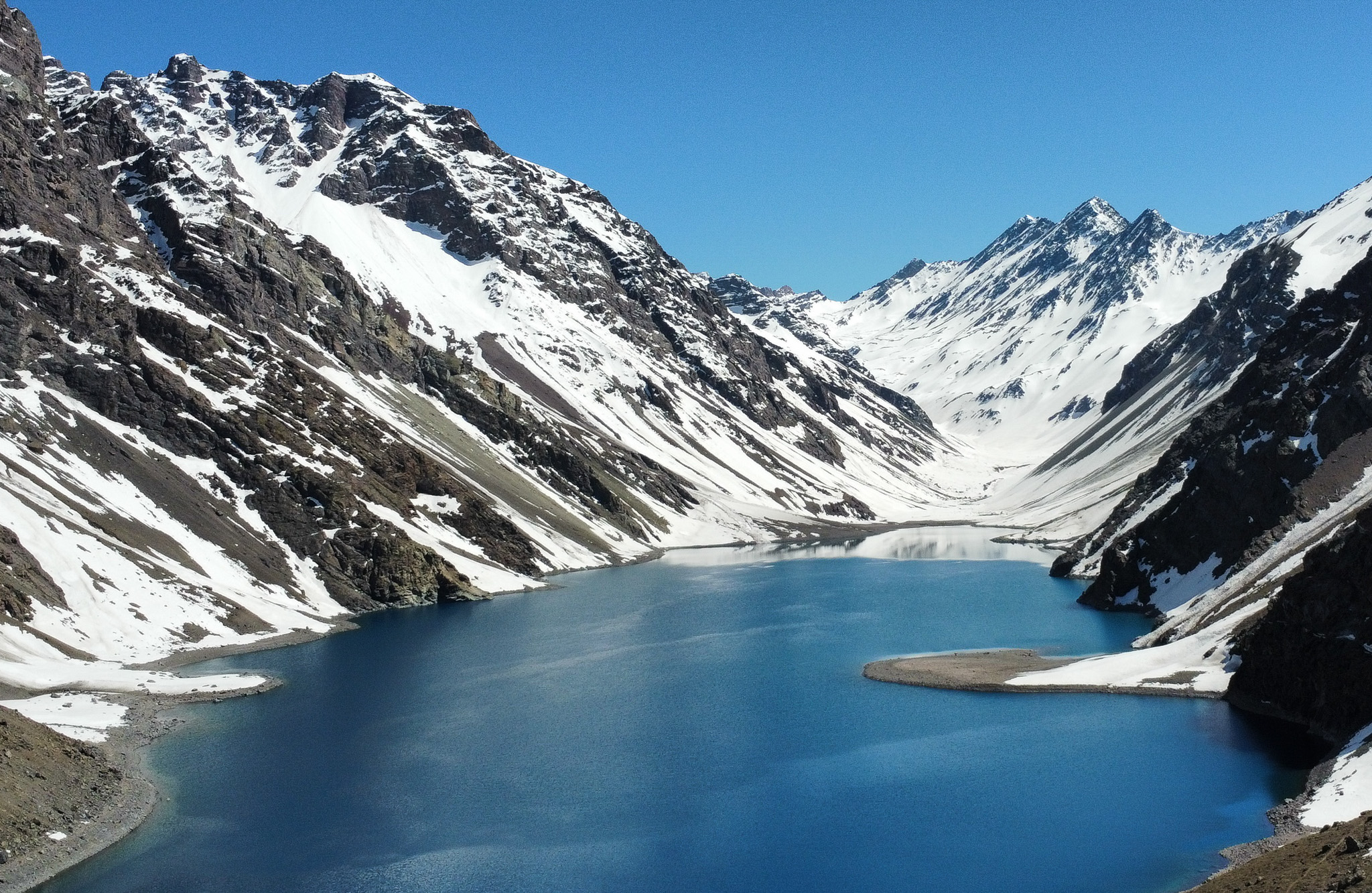 Vista da Laguna del Inca em Portillo durante o verão, com montanhas áridas e águas azul-turquesa